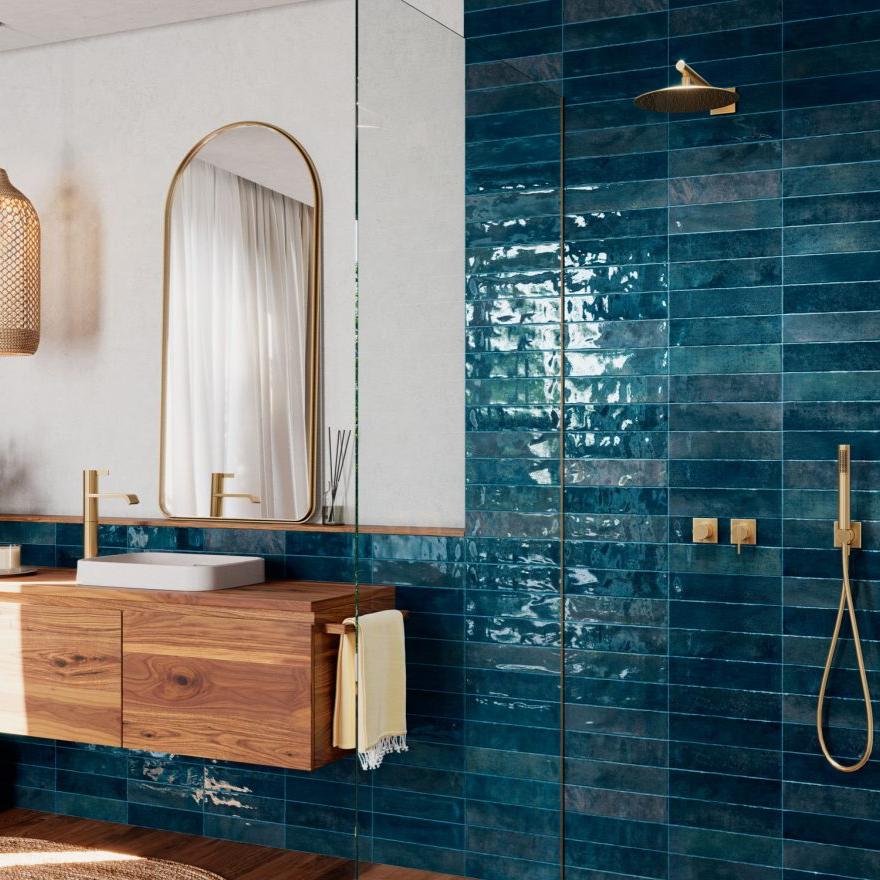 Nairobi Blue artisan style glossy ceramic subway tile with non-flat edge and surface. Installed on a bathroom wall.