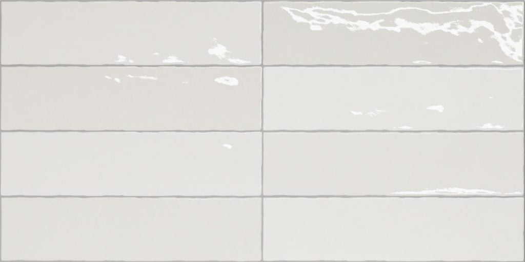 Nairobi White artisan style glossy ceramic subway tile with non-flat edge and surface. Made in Spain, in a 3x12" size.