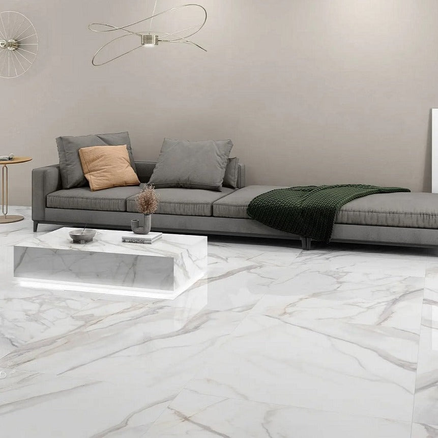 Radiant Calacatta porcelain tile with a white and grey marble design, for floors and walls. Installed in a room.