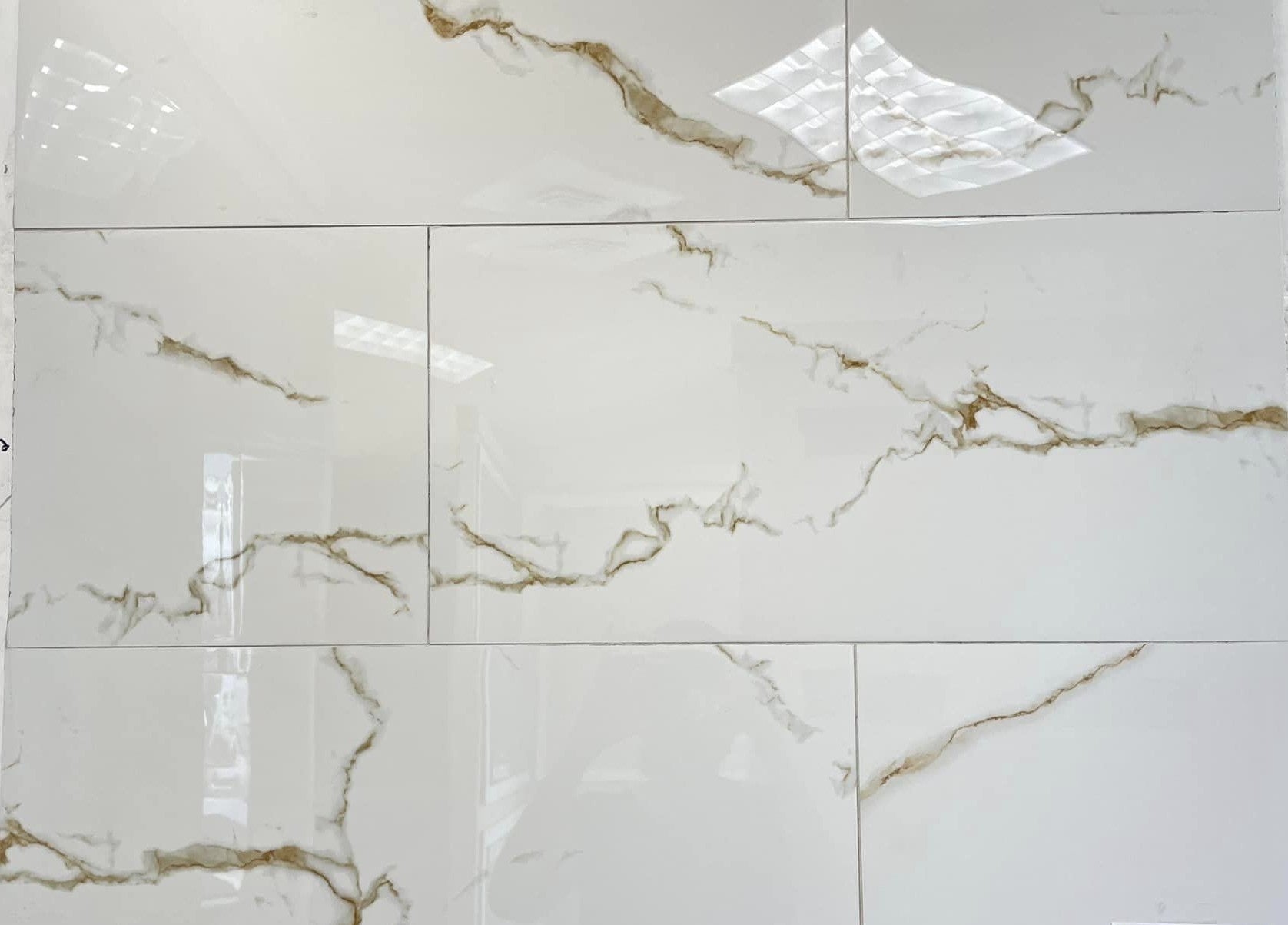 Statuario Golden polished porcelain tile with a white marble design, for floors and walls. In a 12x24" size.