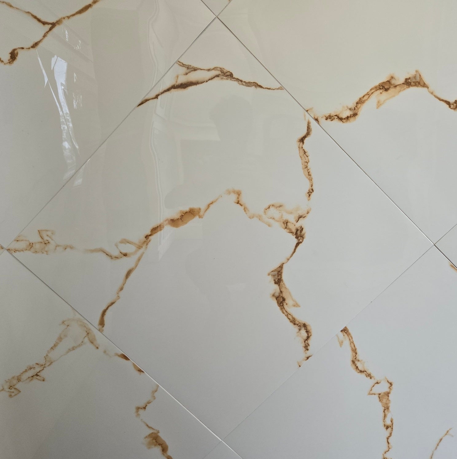 Statuario Golden polished porcelain tile with a white marble design, for floors and walls. In a 24x24" size.