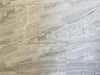 Tuscan Moon polished porcelain tile with a grey stone design, for floors and walls. In a 12x24" size.