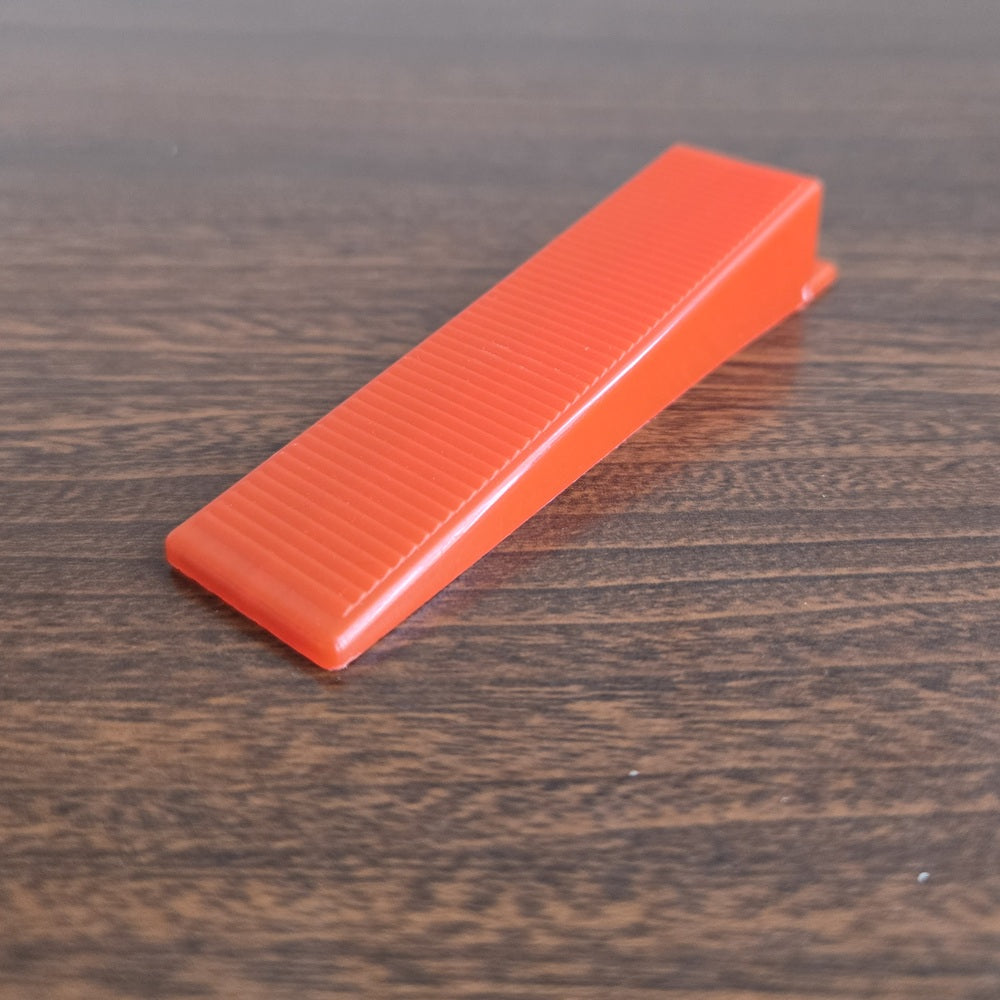 Tile Leveling Wedge to be inserted into a tile leveling clip to ensure level tile surface. In a red colour.