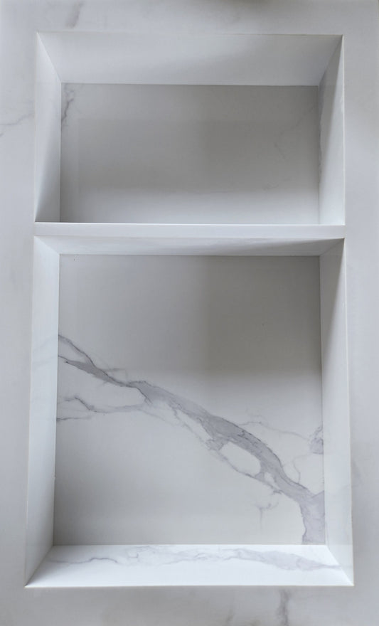 White Carrara prebuilt quartz shower niche made of engineered stone that offers shower storage, with a shelf.